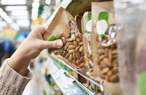 Person picking nuts from a store shelf