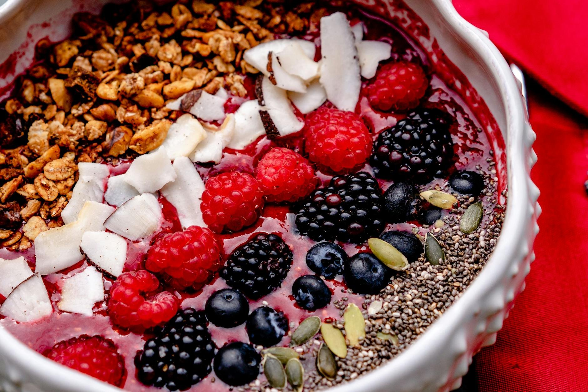 overhead shot of a colorful, nutrient-rich smoothie bowl with berries and seeds - hidden causes low energy