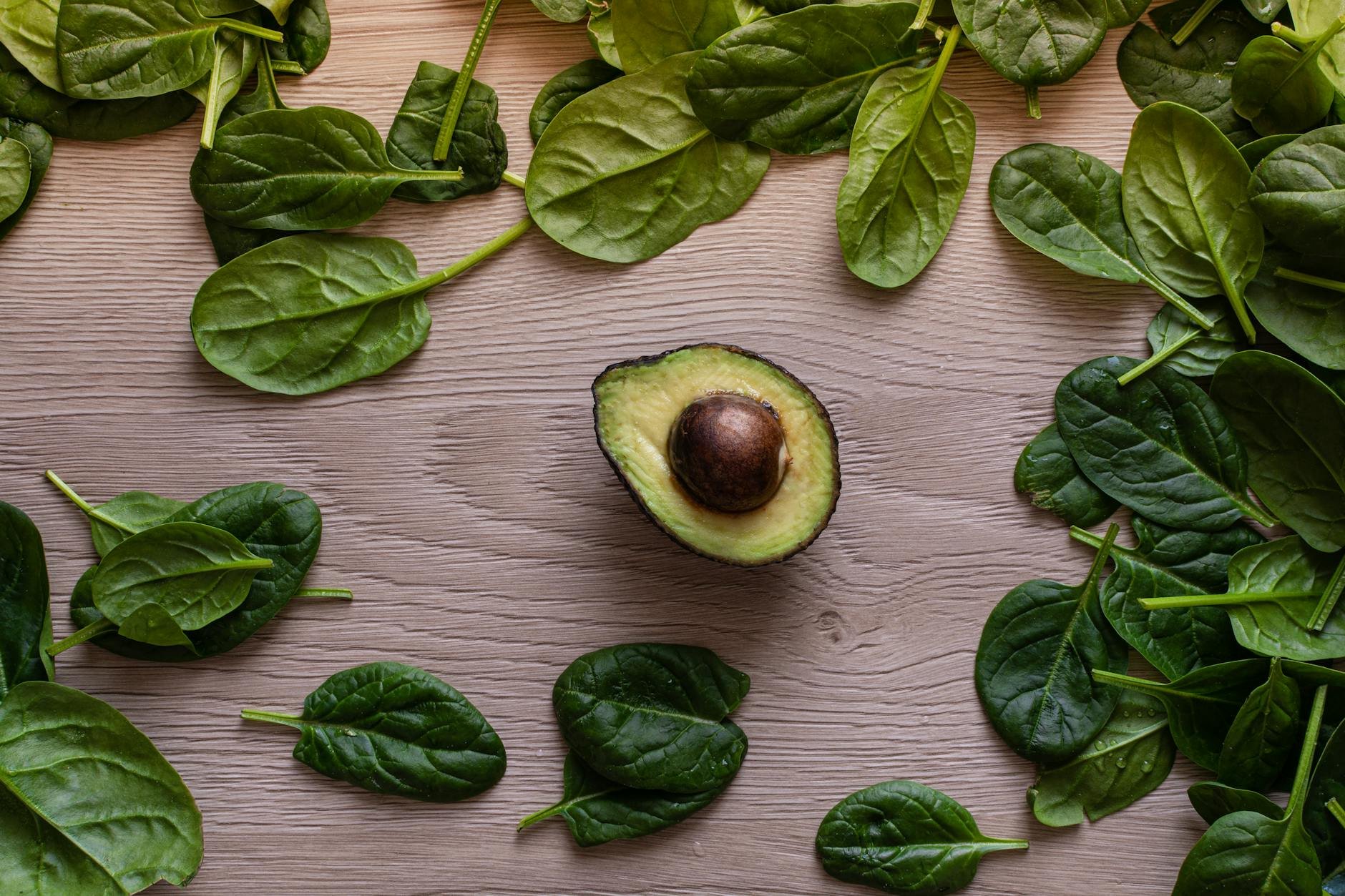 Overhead shot of a vibrant assortment of gut-healthy foods: kefir, sauerkraut, berries, leafy greens, avocado, and salmon on a wooden table. - Gut Health After 40