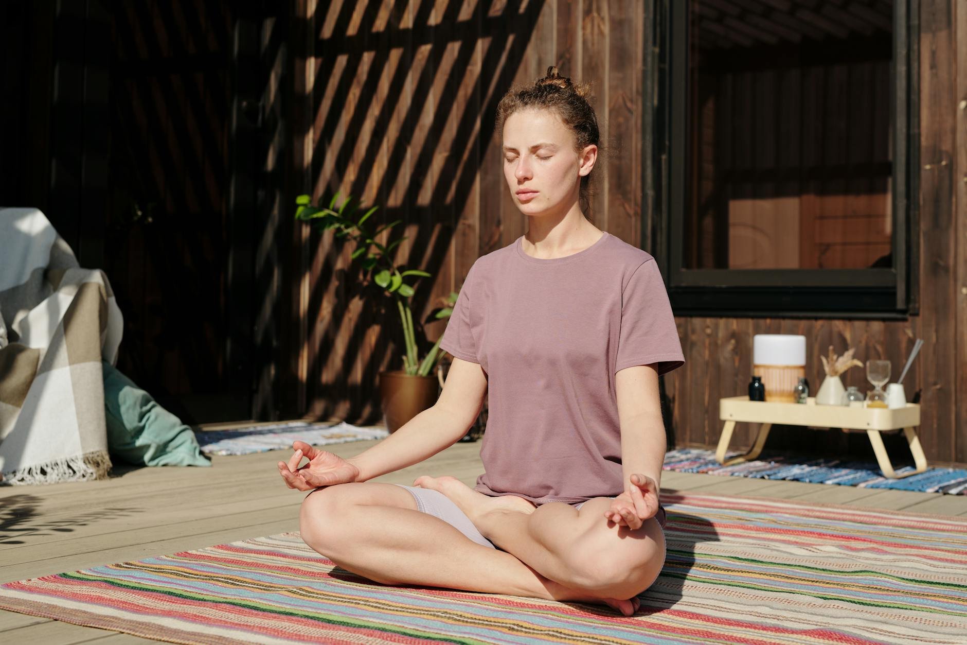 Woman practicing mindful breathing or meditation in a calm, natural setting at sunset - tired emotions