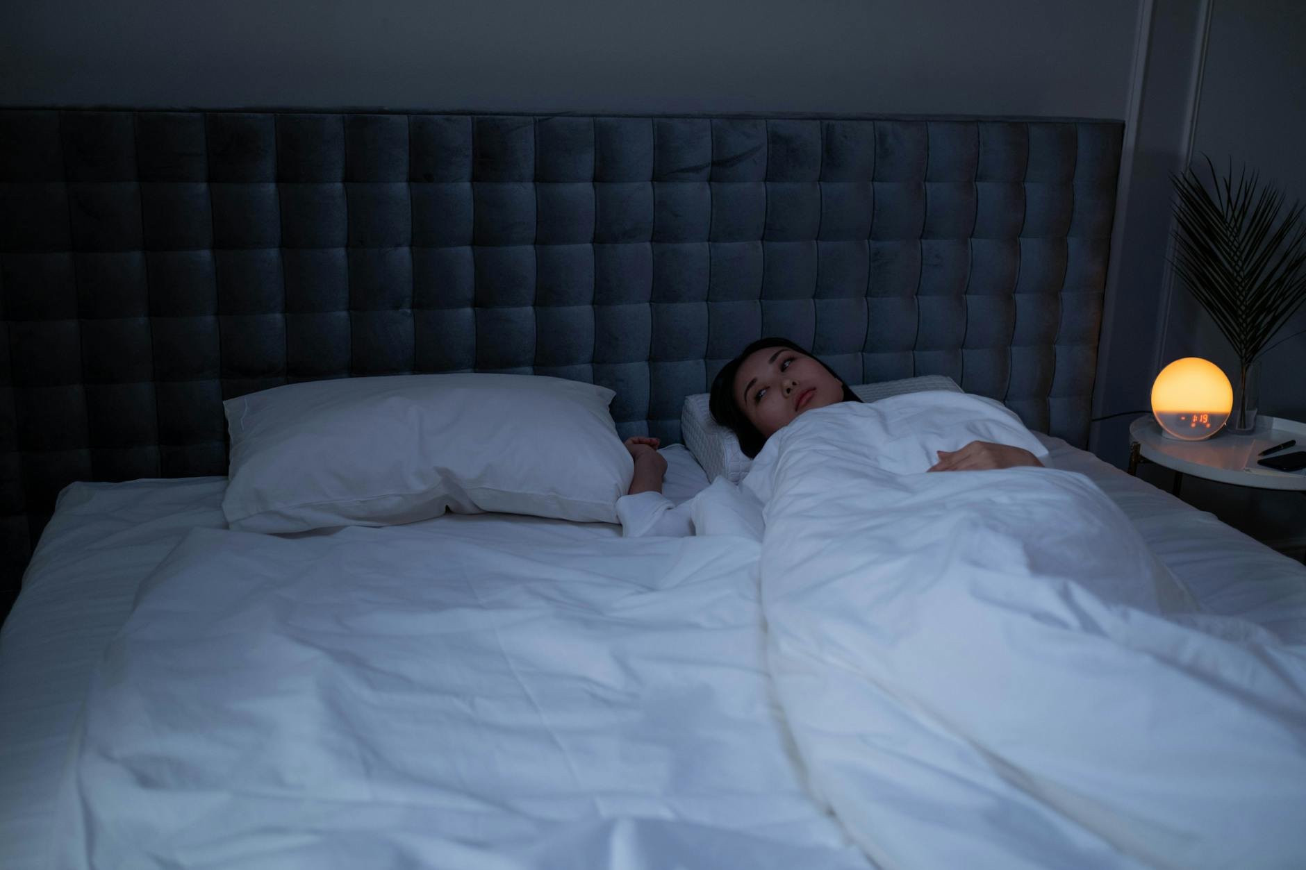 person peacefully sleeping in a cozy bed at night - Magnesium for Sleep