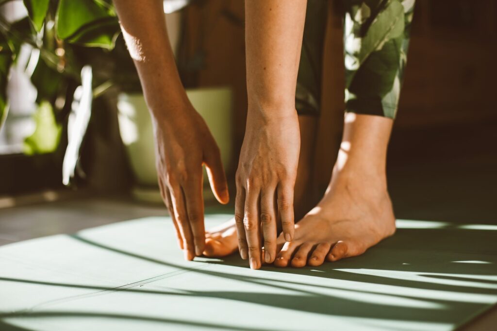 Woman stretching peacefully on yoga mat, morning light - Magnesium Deficiency Signs